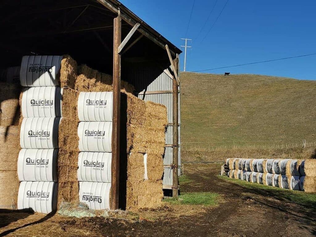 Hay bales are stacked in a barn.